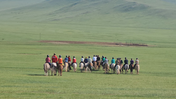 Horse riders crossing the open Mongolian steppe